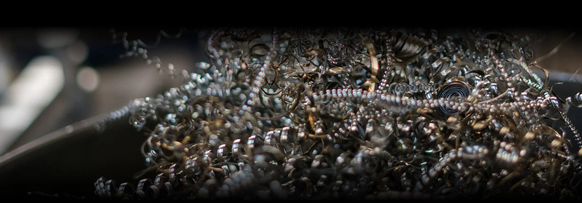 A close-up, dramatic shot of a pile of coiled metallic silver