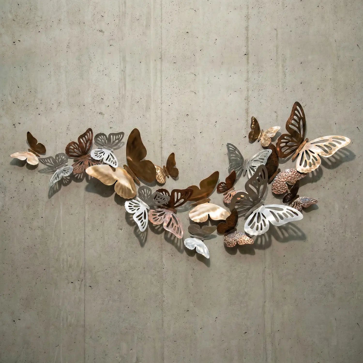 Decorative wall art of metal butterflies on a concrete wall